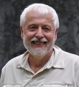 Brad White smiling at the camera in front of a grey backdrop