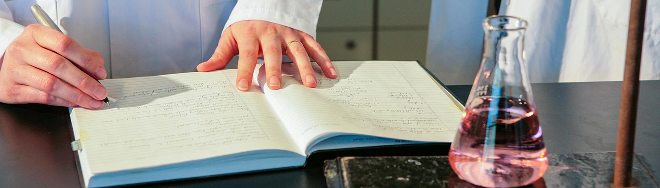 Chemist writing in a lab book
