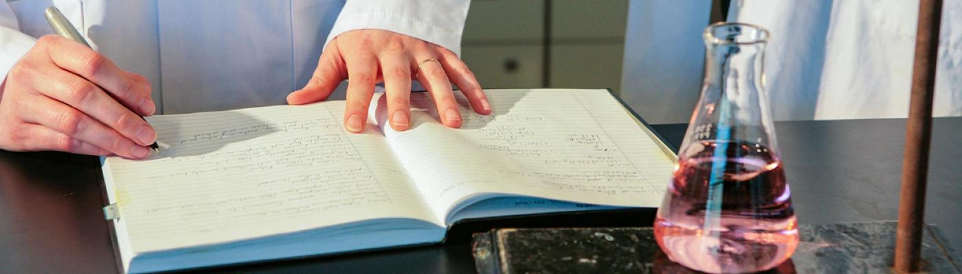 Chemist writing in a lab book